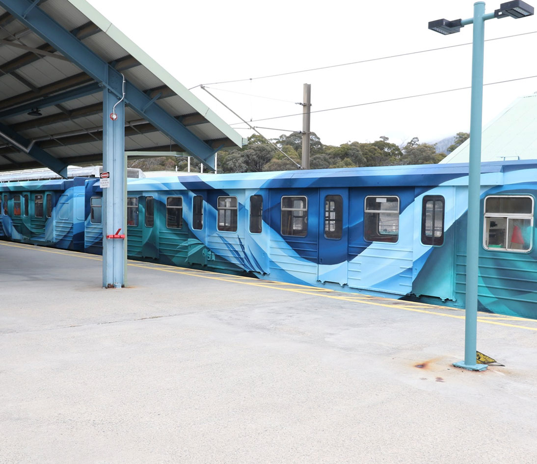 Ski Tube Side Angle Side angle of the Ski Tube train showing the blue abstract artwork at the station.