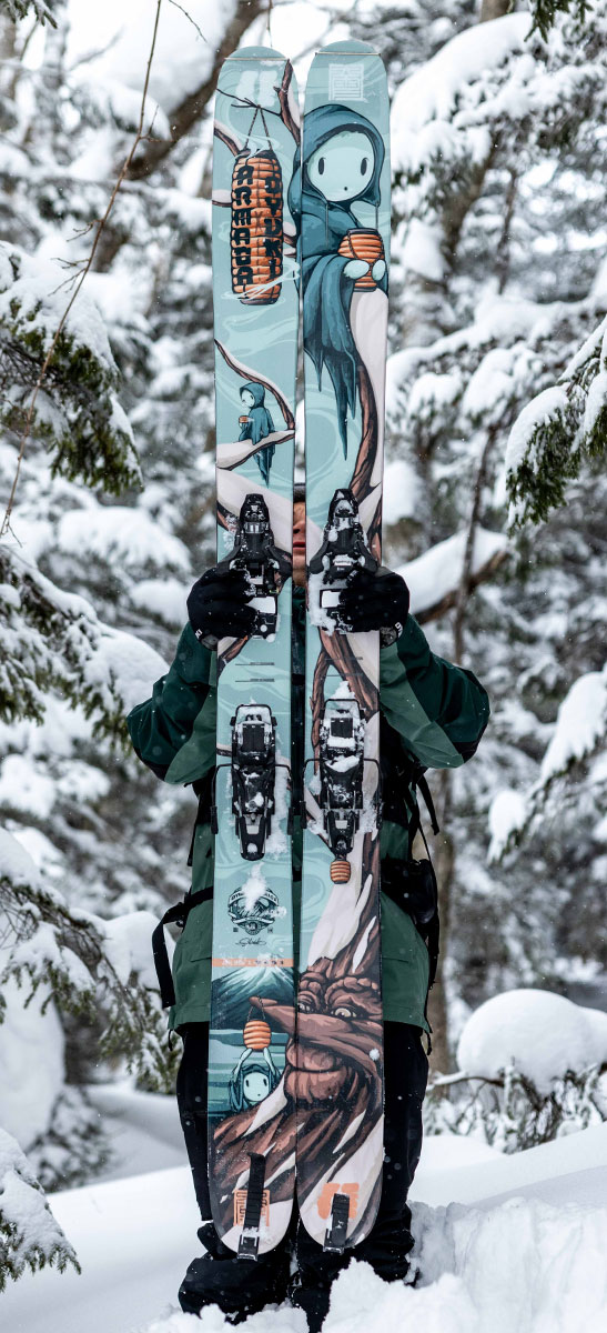 Mike-Shankster-Armada-Kodama-Ski-Artwork-V1 ARV JJ-UL skis featuring Mike Shankster’s Kodama illustration held upright in a snowy forest.
