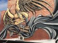 Large eagle mural across a red brick building, with sweeping black and grey ribbon forms, by Mike Shankster