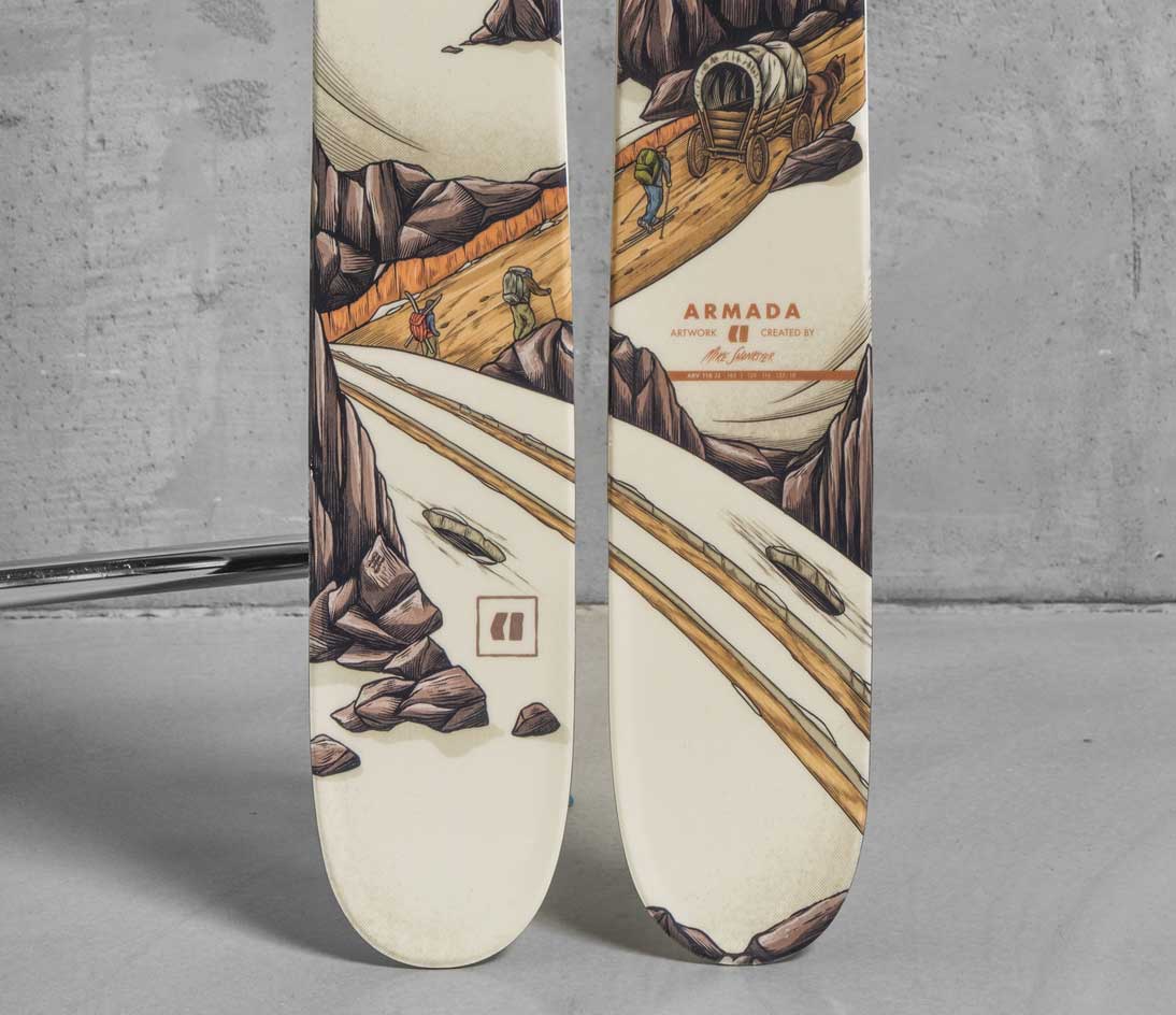 Lower section of Armada skis showing illustrated mountain track scene with hikers, rocks, and a wagon integrated into the ski design.