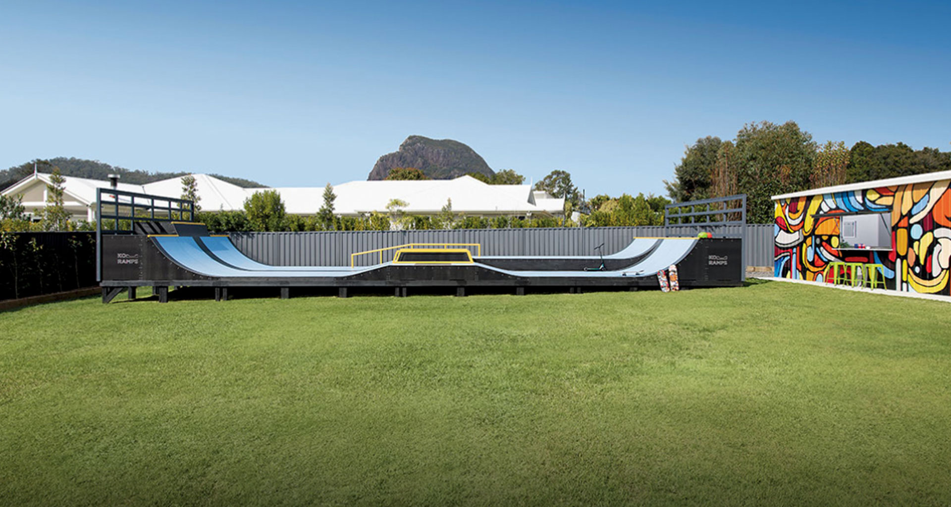 Wide backyard view with skate ramp and colourful shed mural in Glass House Mountains