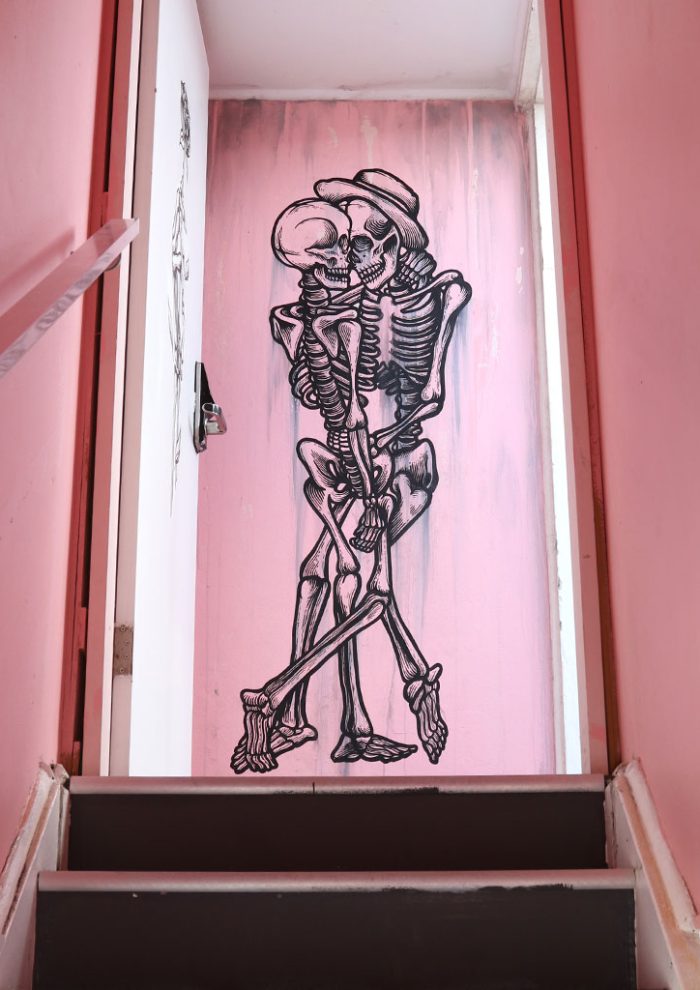 Skeleton lovers mural painted in a doorway at The Pink Hotel in Coolangatta on the Gold Coast by Mike Shankster.