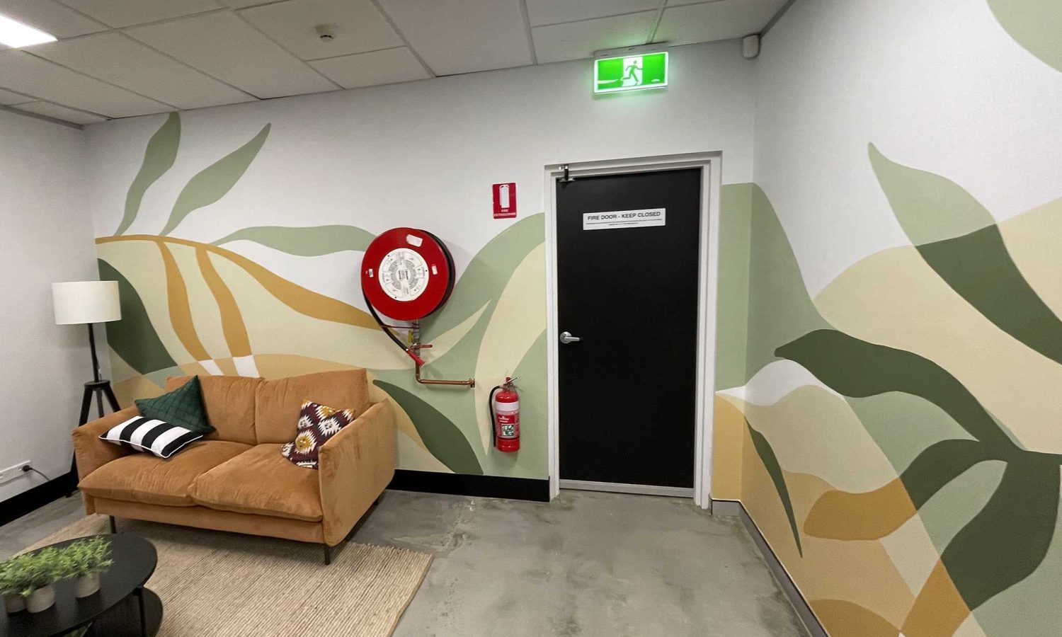 Commercial office mural on the Gold Coast with earthy abstract botanical shapes across a shared workspace